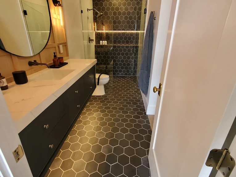 Trendy bathroom with black honeycomb tile flooring