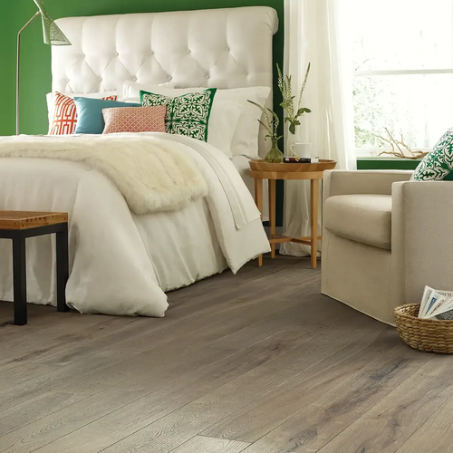 Cozy bedroom with wood floors by Barrett Floors