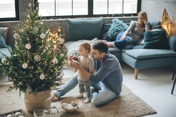 Family decorating Christmas tree in a bright living room